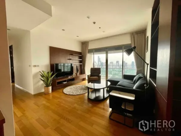 公寓 出租在Watthana, Bangkok - 起居区带电视柜与大窗户，高楼层可观天际线。