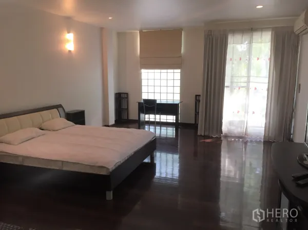 公寓 出租在Watthana, Bangkok - 主卧空间大，木地板，窗边书桌，推拉门连接阳台。