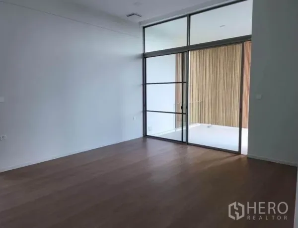独立式住宅 出租在Saphan Sung, Bangkok - 采光充足的起居区，木地板、挑高空间，大幅推拉玻璃门通往阳台。