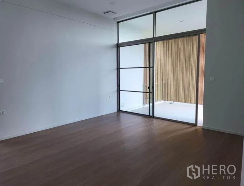 独立式住宅 出租在Saphan Sung, Bangkok - 采光充足的起居区，木地板、挑高空间，大幅推拉玻璃门通往阳台。