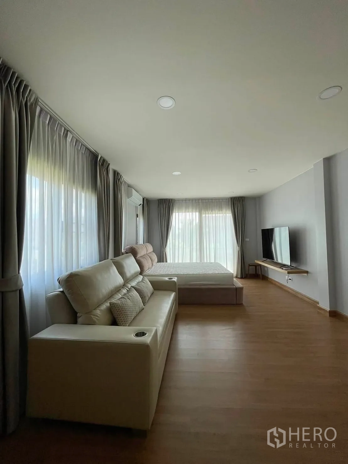 Detached House for rent in Bang Phli, Samut Prakan - Spacious master bedroom with a sofa, bed, TV unit, and wraparound floor-to-ceiling curtains.