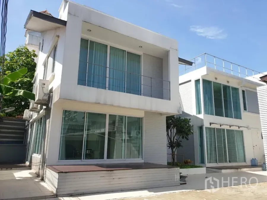 บ้าน ให้เช่าในKhlong Toei, Bangkok - บ้านเดี่ยวสองชั้นสไตล์โมเดิร์นสีขาว หน้าต่างบานใหญ่ พร้อมลานจอดรถย่านสุขุมวิท