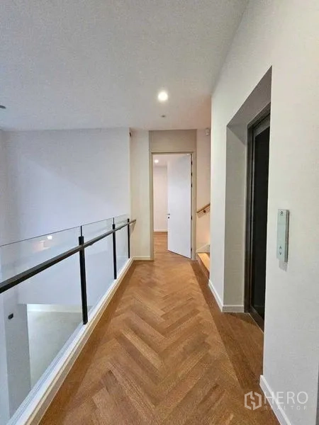 Detached House for rent in Wang Thonglang, Bangkok - Corridor with glass balustrade next to the elevator access.