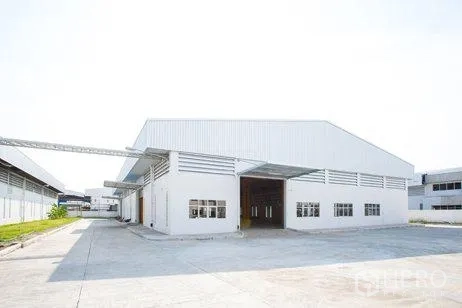 工厂 出租在Chachoengsao - 现代厂房前的宽阔混凝土场地与大型装卸入口。
