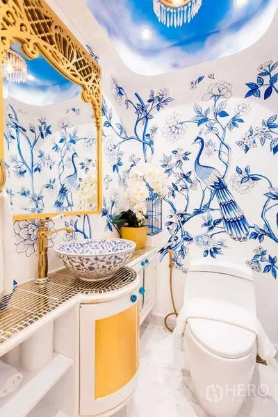 Townhouse for rent in Lat Phrao, Bangkok - Powder room with blue bird wall art, vessel sink and gold-framed mirror.