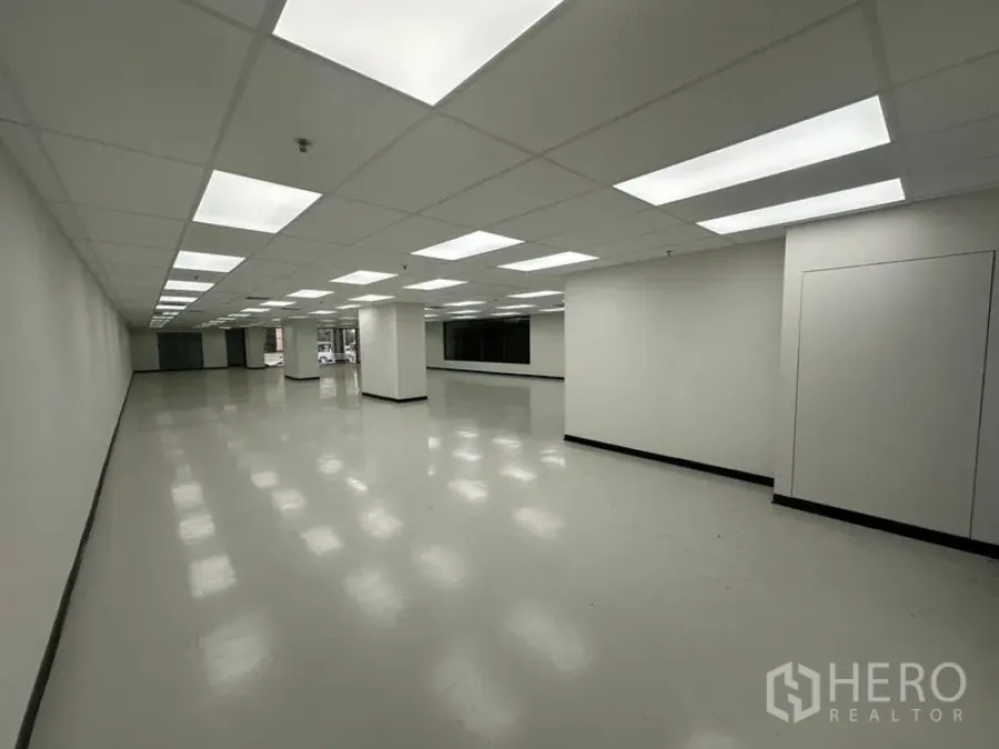 办公空间 出租在Phaya Thai, Bangkok - 长方形办公室，整齐布置的LED灯，少量立柱与侧向窗户。
