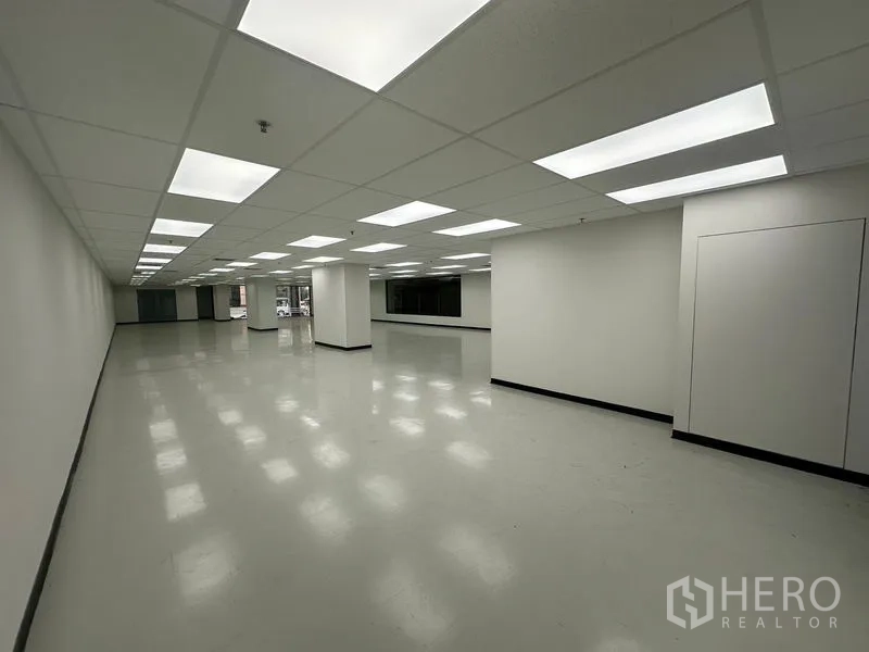 办公空间 出租在Phaya Thai, Bangkok - 长方形办公室，整齐布置的LED灯，少量立柱与侧向窗户。