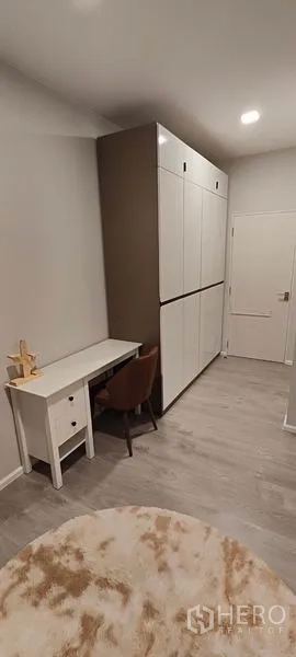 Detached House for rent in Prawet, Bangkok - Hallway dressing area with tall built-in wardrobes and compact study nook.