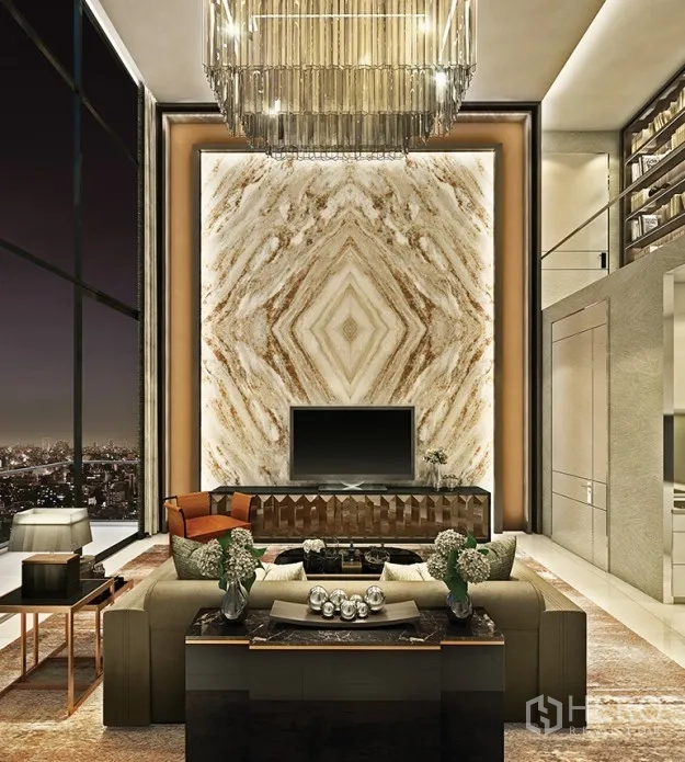 Condominium for sale in Watthana, Bangkok - Luxurious double-height lounge with chandelier and a dramatic marble feature wall.