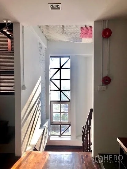 店屋 出租在Pathum Wan, Bangkok - 楼梯间设高挑格栅窗，自然光充足，配木质扶梯。