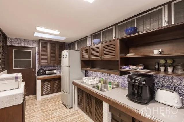 Detached House for rent in Watthana, Bangkok - Spacious kitchen with wooden cabinets, patterned backsplash and full appliances.