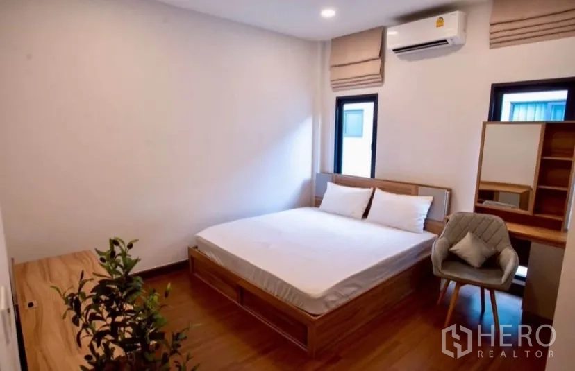 独立式住宅 出租在Bang Phli, Samut Prakan - 采光卧室，木床、小书桌与空调。