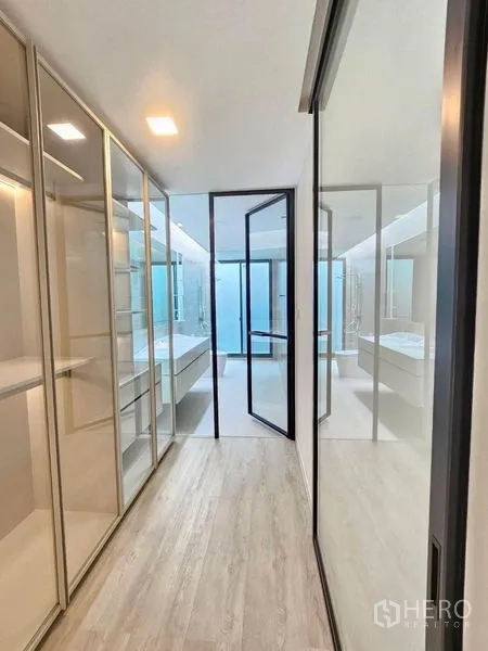 Detached House for rent - Glass‑lined corridor with fitted wardrobes leading toward a bright bathroom.
