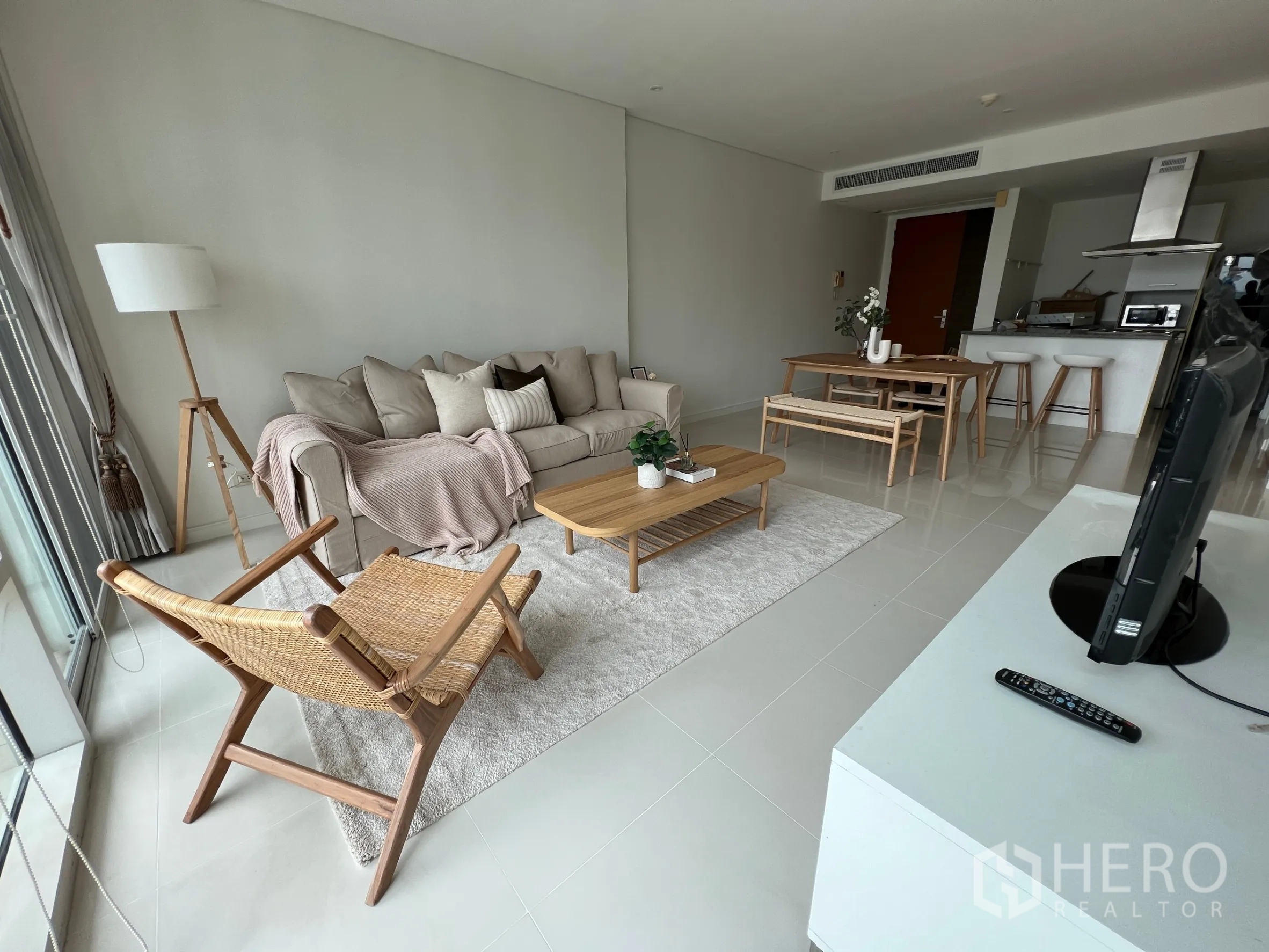 คอนโด ให้เช่าในWatthana, Bangkok - ห้องนั่งเล่นแบบโอเพ่นสเปซสว่าง โซฟาสีเบจ ตู้ทีวี และชุดโต๊ะรับประทานอาหารในคอนโดสมัยใหม่