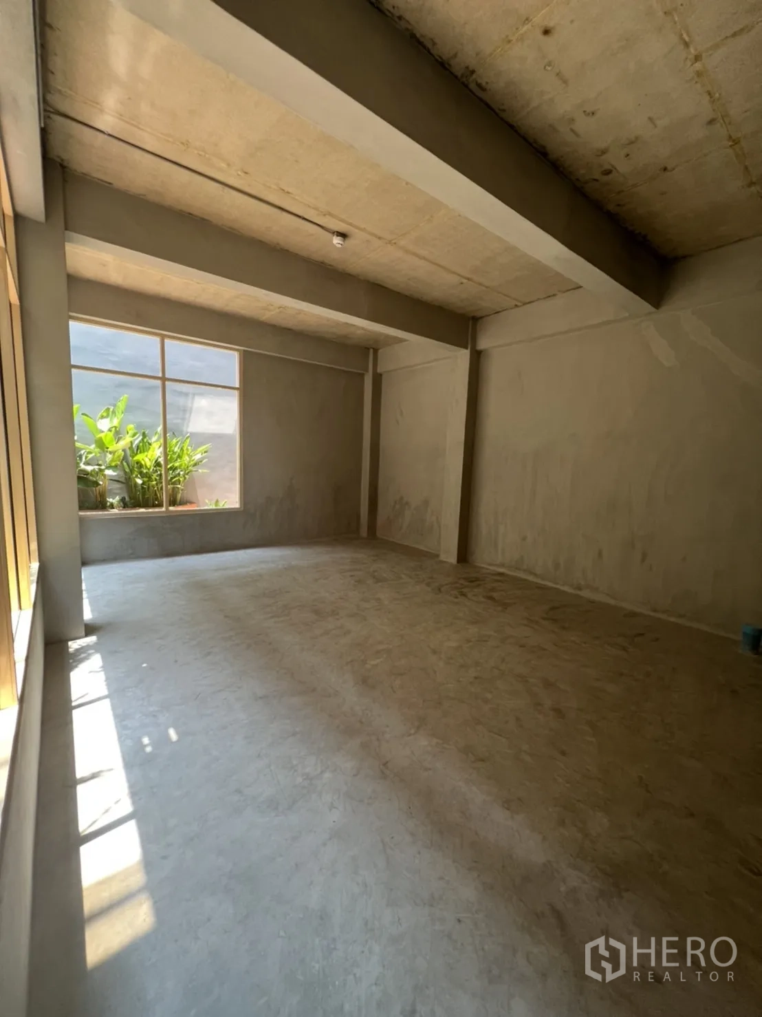 Retail Space for rent in Watthana, Bangkok - Unfurnished retail interior with high ceiling, exposed beams and natural light from side window.