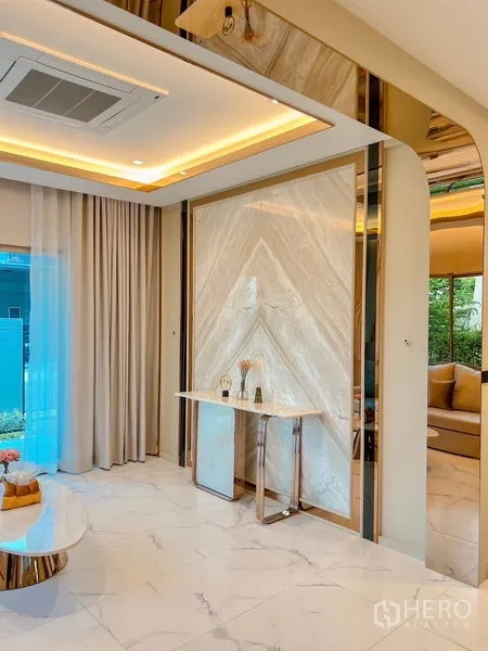独立式住宅 出售在Bang Kapi, Bangkok - 客厅大理石纹特色墙，隐藏灯带与精致玄关柜。