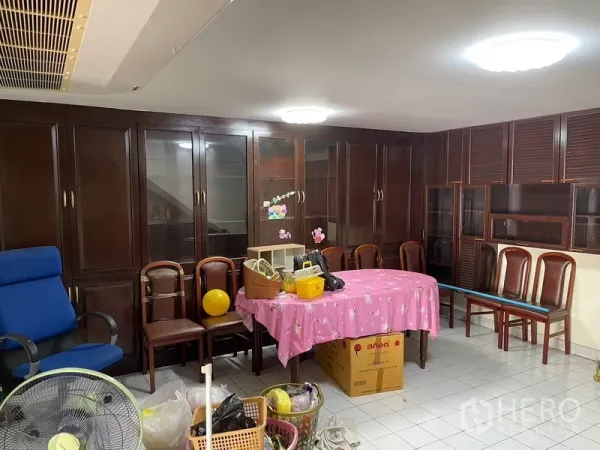 Home Office for rent in Watthana, Bangkok - Room with dark wood built-in cabinets, tiled floor and chairs, suitable for storage or meeting space.