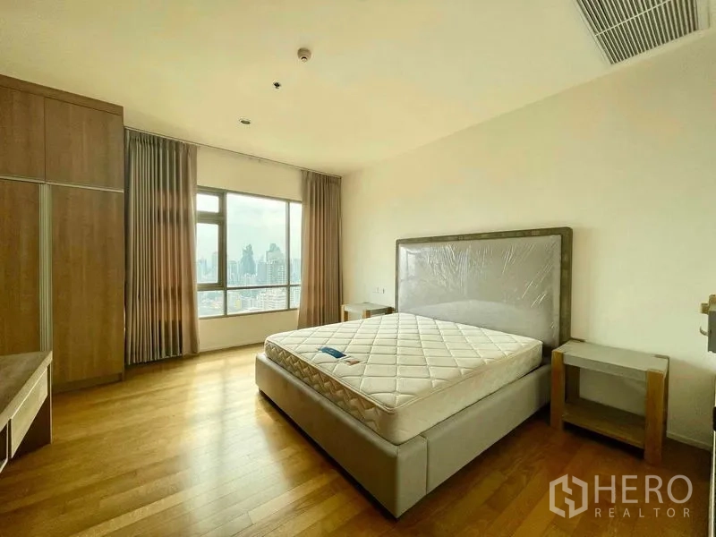 公寓 出租在Watthana, Bangkok - 宽敞卧室，城市景观窗、床架与定制衣柜。