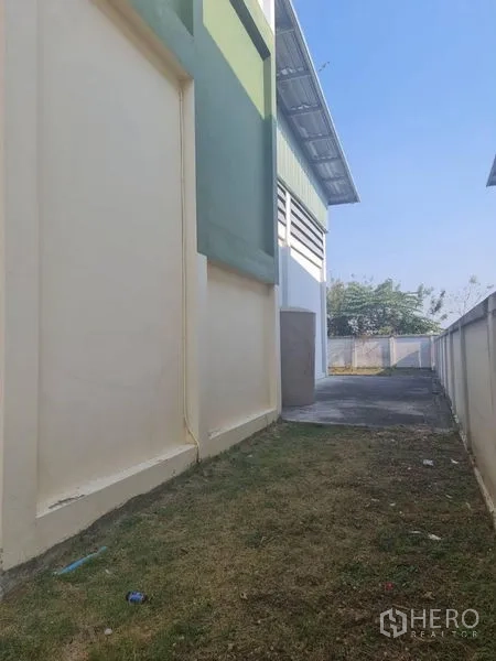 工厂 出租或出售在Lam Luk Ka, Pathum Thani - 建筑侧边通道，草带与混凝土小路。
