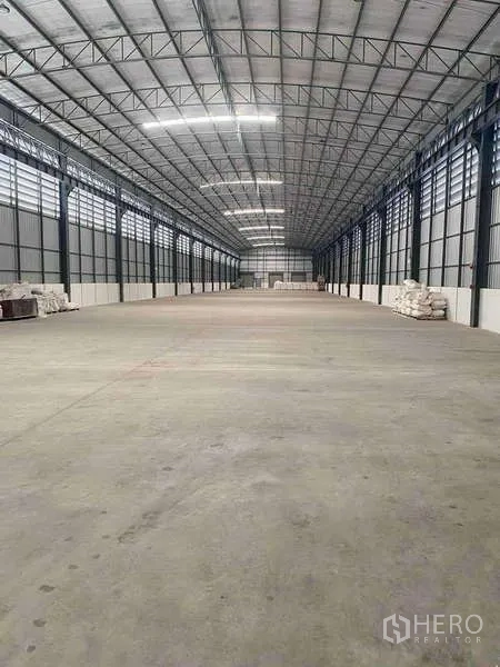 Warehouse for rent in Si Racha, Chon Buri - Spacious clear-span warehouse interior with high steel roof and smooth concrete floor