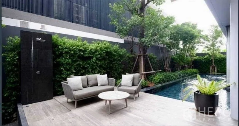 独立式住宅 出售在Huai Khwang, Bangkok - 泳池畔露台配沙发座与户外花洒，绿篱环绕更私密。