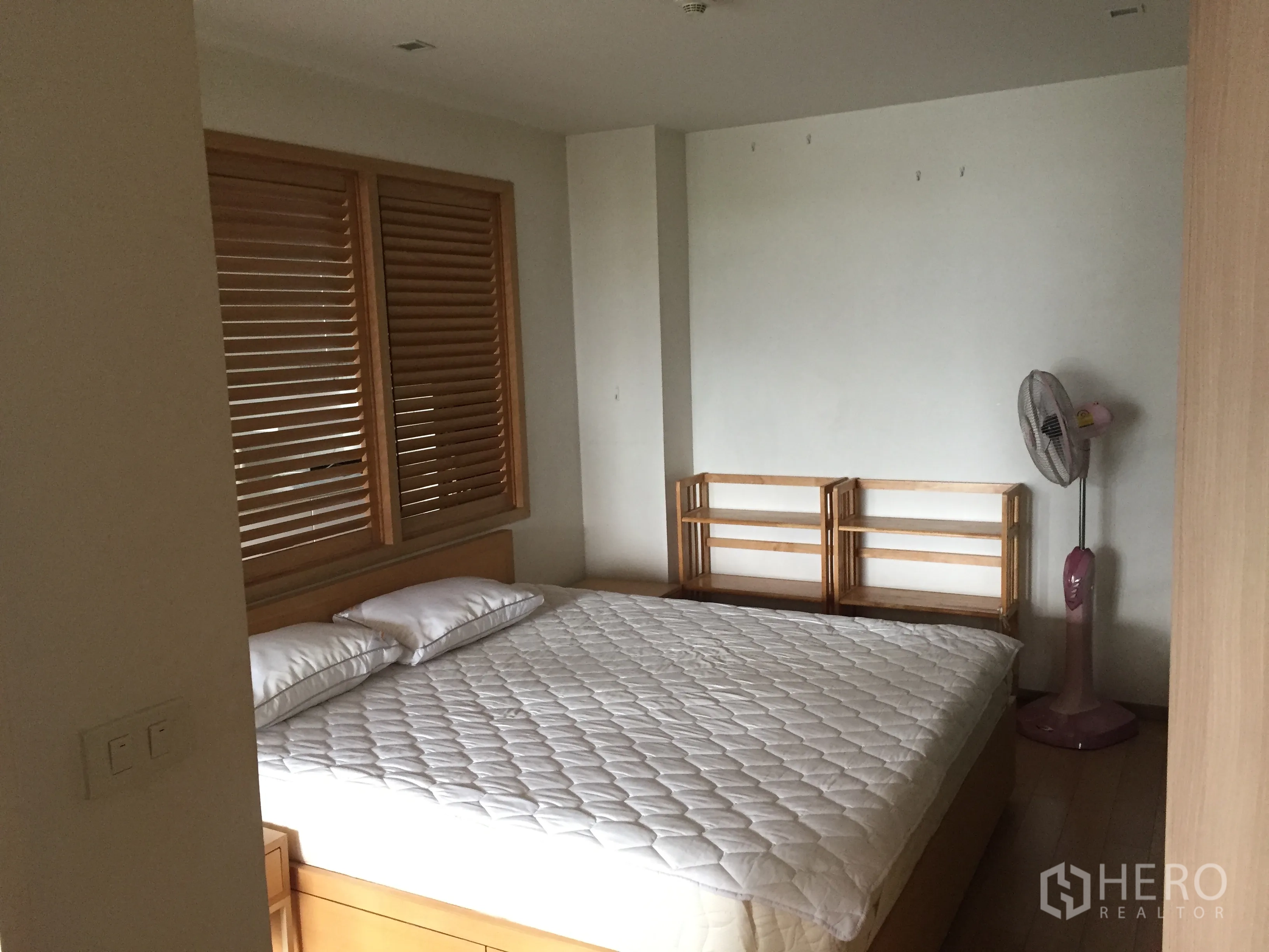 公寓 出租在Pathum Wan, Bangkok - 温馨卧室，配大床、木质百叶与极简置物架，色调素雅。