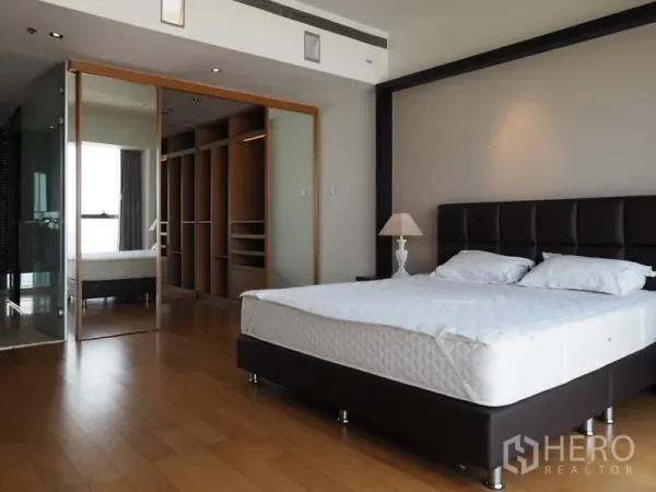 Condominium for rent in Sathon, Bangkok - Primary bedroom featuring a king bed, walk-in closet and glass-walled ensuite bathroom.