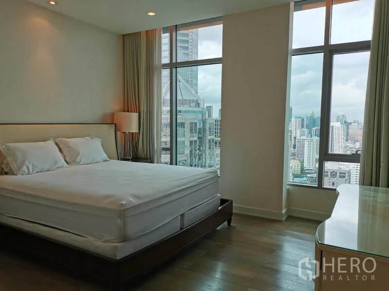Condominium for rent in Pathum Wan, Bangkok - Spacious bedroom with floor-to-ceiling windows and expansive city views.