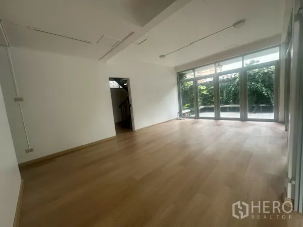 独立式住宅 出租在Watthana, Bangkok - 宽敞开放式起居区，大窗看花园，浅色木地板。