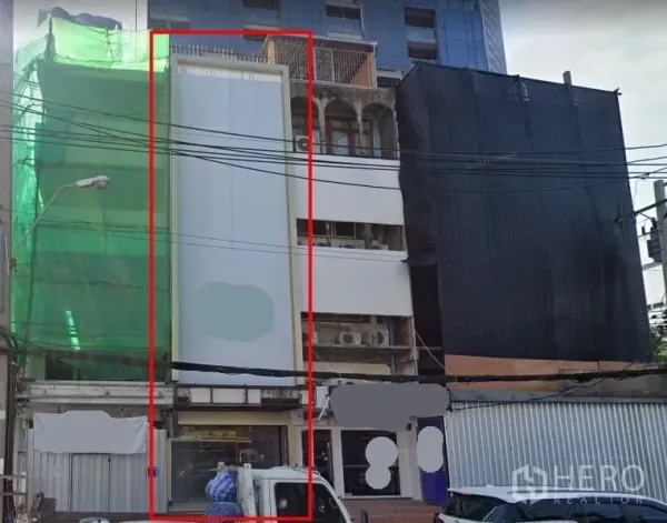 Shophouse for rent in Watthana, Bangkok - Narrow multi-storey shophouse facade highlighted between neighboring buildings.