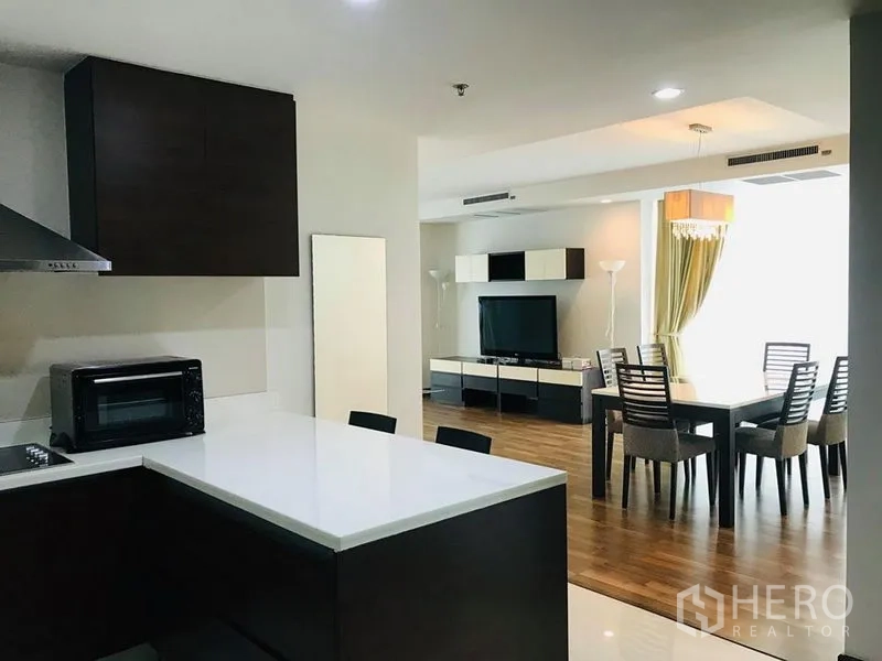 公寓 出租在Pathum Wan, Bangkok - 开放式厨房连接客餐厅，可见六人餐桌与电视区。