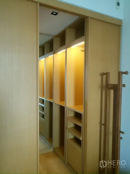 Condominium for rent in Sathon, Bangkok - Walk-in closet with illuminated shelving and mirrored sliding doors.