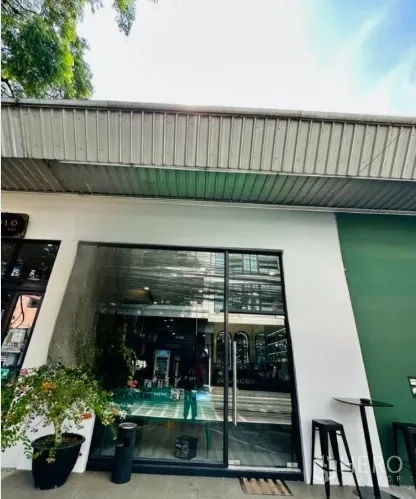 零售空间 出租在Watthana, Bangkok - 临街店面外观，整面玻璃门，绿白色外墙与金属雨棚，通罗商铺