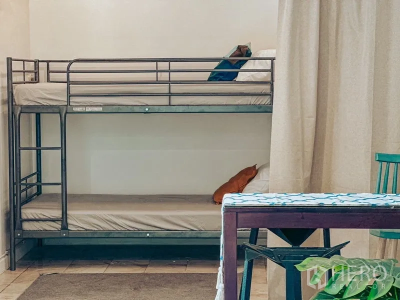 带办公室的家 出租在Watthana, Bangkok - 金属双层床靠浅色墙摆放，临近餐桌区域。