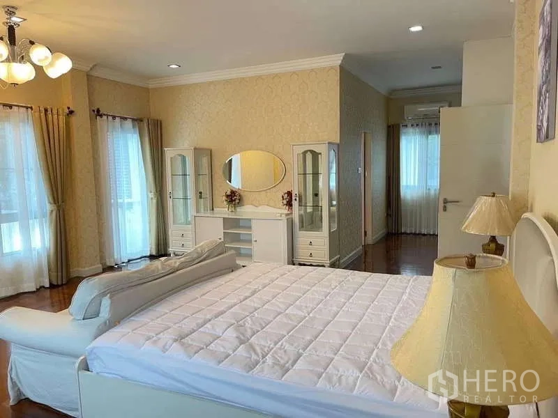 独立式住宅 出租在Mueang Nonthaburi, Nonthaburi - 宽敞主卧，特大床、白色家具、木地板与多扇窗户。