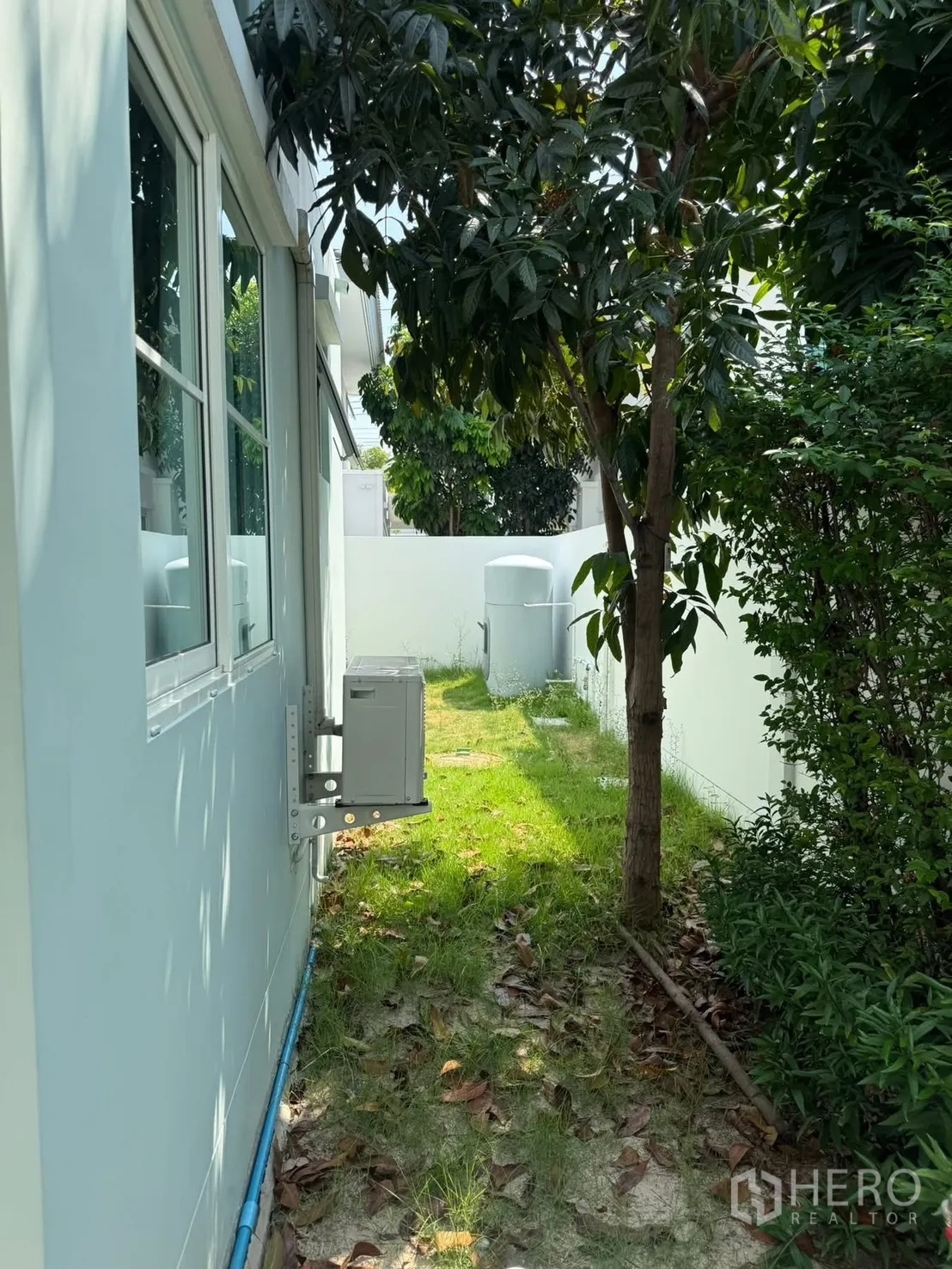 บ้านเดี่ยว for rent in Bang Phli, Samut Prakan - สวนข้างบ้านมีสนามหญ้า ต้นไม้ พุ่มไม้ และคอมเพรสเซอร์แอร์ติดผนัง