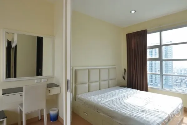 公寓 出租在Ratchathewi, Bangkok - 温馨卧室，软包床头、梳妆台与宽窗，可欣赏城市景观。