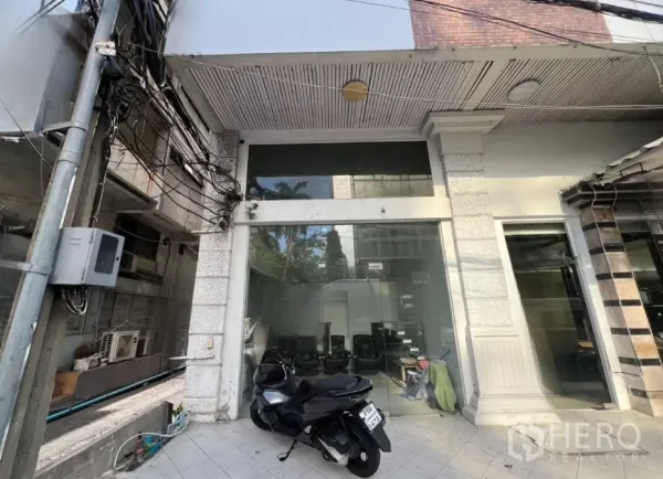 Retail Space for rent - Street-level retail storefront with full-height glass facade and tiled forecourt in central Bangkok.