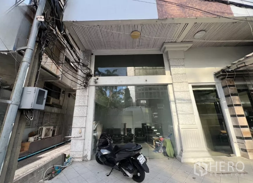 Retail Space for rent - Street-level retail storefront with full-height glass facade and tiled forecourt in central Bangkok.