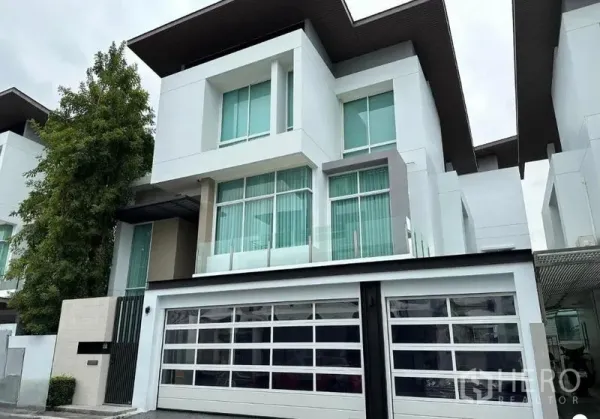 บ้าน ขายในSuan Luang, Bangkok - ด้านหน้าบ้านสมัยใหม่สามชั้น หน้าต่างบานใหญ่และประตูเลื่อน