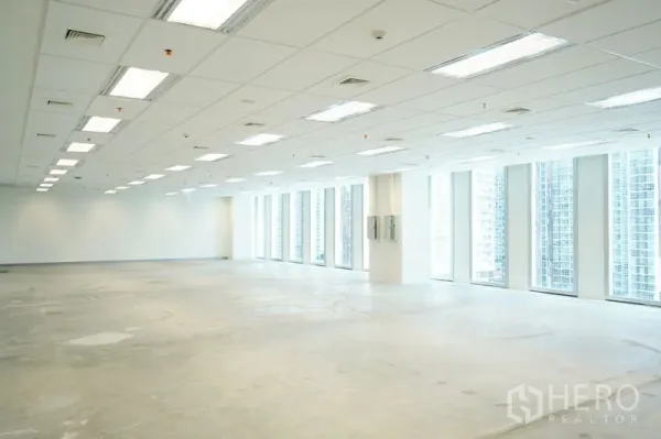Office Space for rent in Bang Na, Bangkok - Expansive office plate with linear LED lighting and full‑height windows along one side.