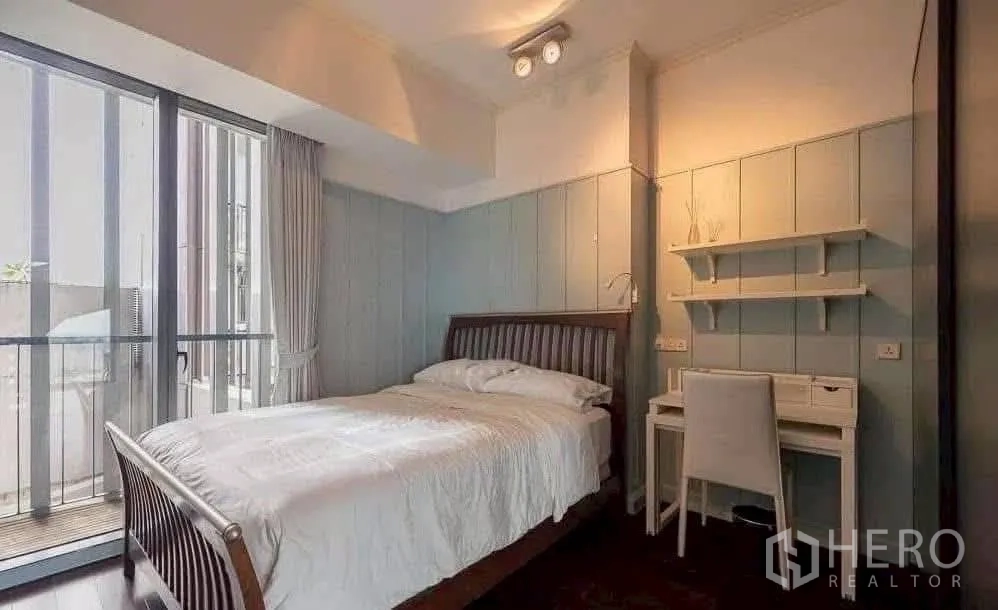 Condominium for rent in Sathon, Bangkok - Bright guest bedroom with study desk, wall shelves and balcony access.