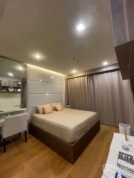 公寓 出售在Bang Rak, Bangkok - 宽敞主卧，设大床、梳妆台与遮光窗帘。