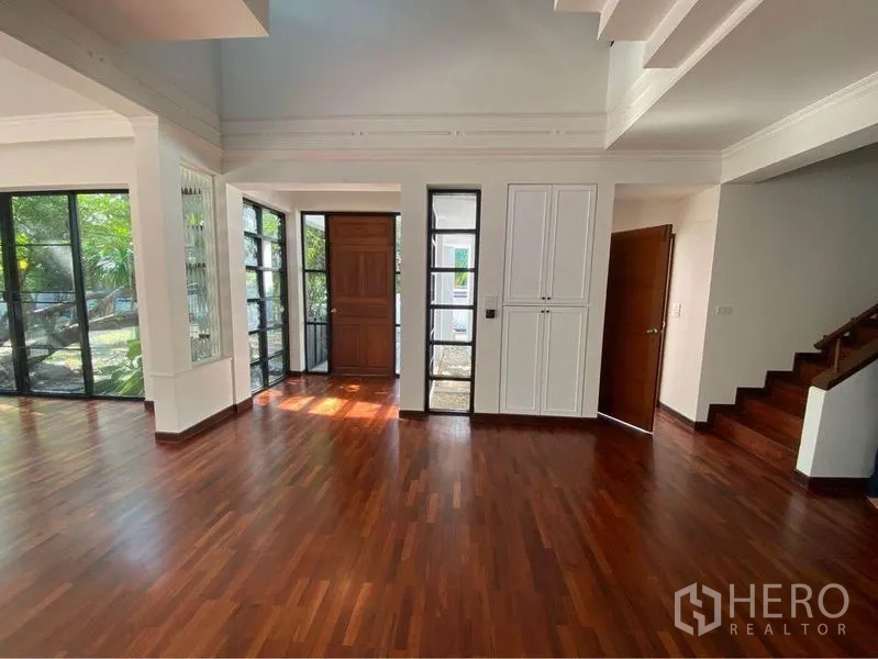 บ้าน ให้เช่าในWatthana, Bangkok - โถงทางเข้าพร้อมผนังกระจก ประตูไม้ และบันได