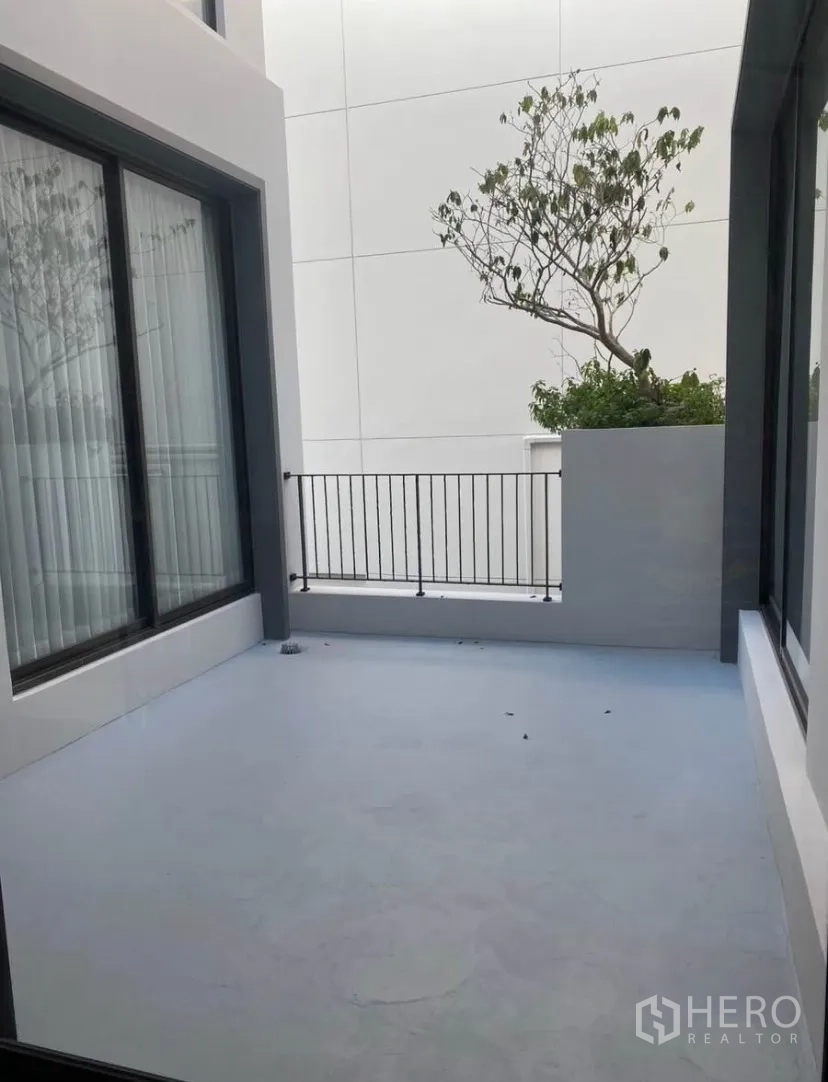 Detached House for rent or sale in Lat Krabang, Bangkok - Private open‑air terrace with railing between full‑height glass doors