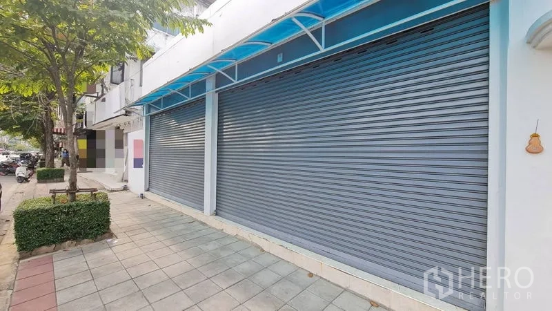 店屋 出租 - 带蓝色雨棚与双卷闸的店铺外立面与人行道