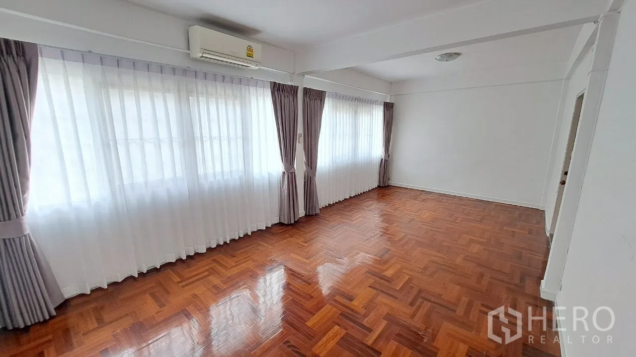 联排别墅 出租在Watthana, Bangkok - 大卧室，空调、整排窗帘与木地板。