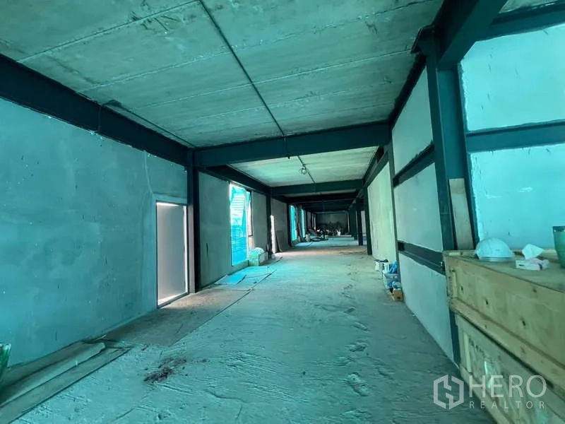 Retail Space for rent in Pathum Wan, Bangkok - Long corridor-like space with unfinished walls, side windows and scattered construction tools.