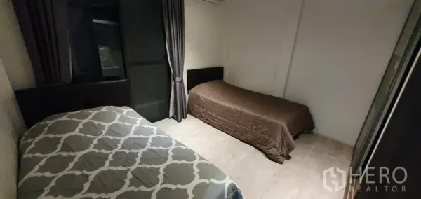 Detached House for rent in Prawet, Bangkok - Twin-bed bedroom with dark curtains and wood floors.