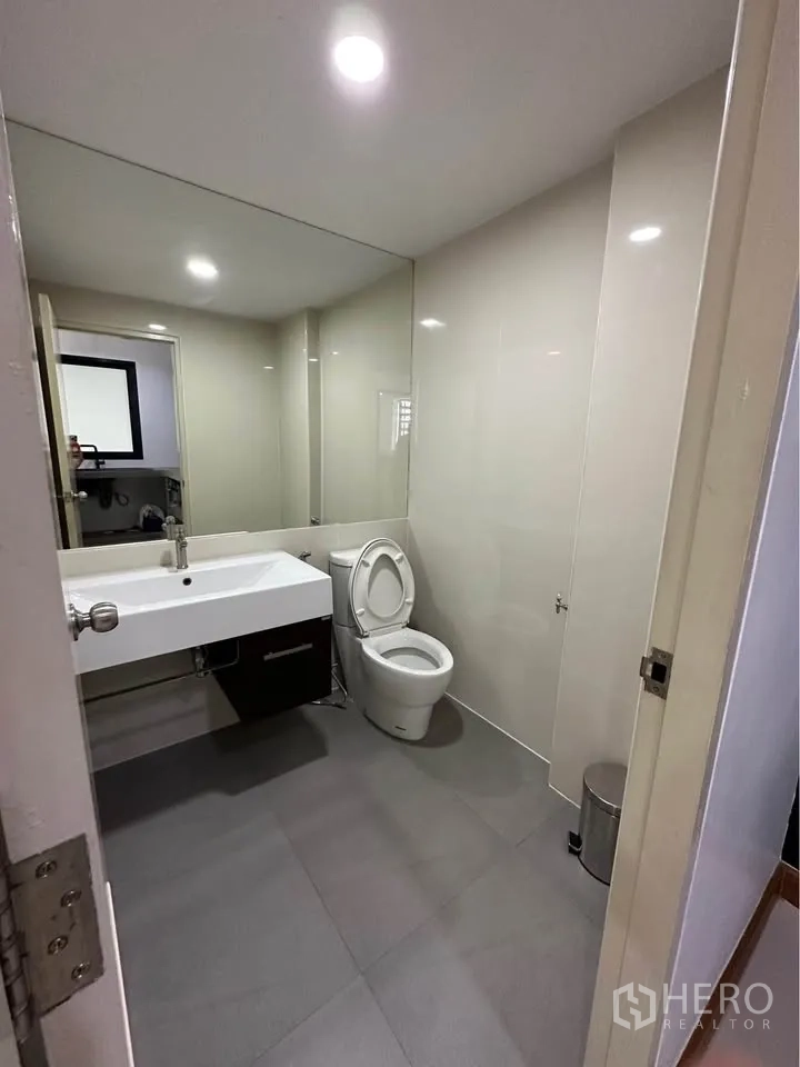 联排别墅 出租在Pak Kret, Nonthaburi - 现代卫浴，大镜面、台盆与坐便器。